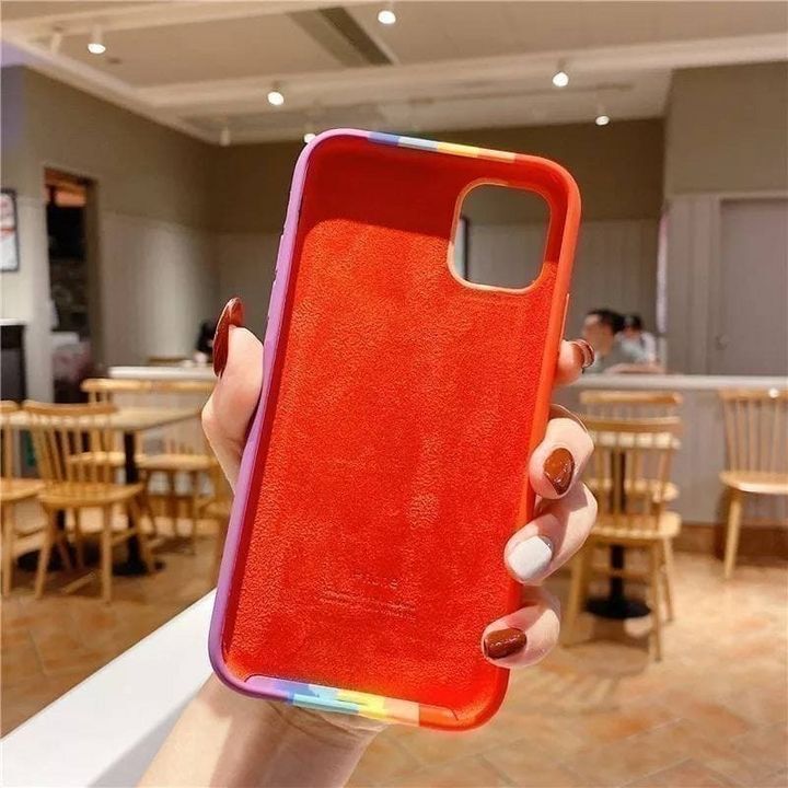  کاور سیلیکونی رنگین کمانی مناسب برای گوشی اپل iPhone 11 Pro Max با طراحی رنگارنگ و جنس مقاوم در دست یک فرد 