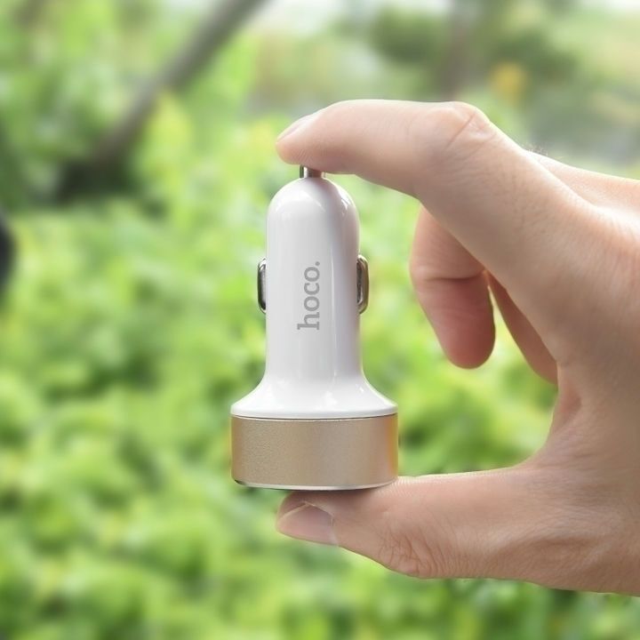  شارژر فندکی هوکو مدل Z26 در دست فردی با پس‌زمینه‌ی سبز 