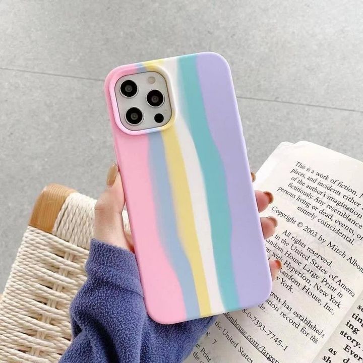 کاور سیلیکونی رنگین کمانی مناسب برای گوشی موبایل اپل iPhone 12 / 12 PRO در دست شخصی با ژاکت بنفش.