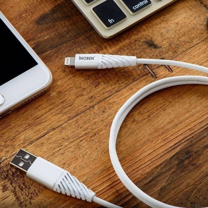  کابل تبدیل USB به لایتنینگ آینوبن مدل TPE با طول 1.2 متر در حالت اتصال به دستگاه‌های دیجیتال روی میز چوبی 