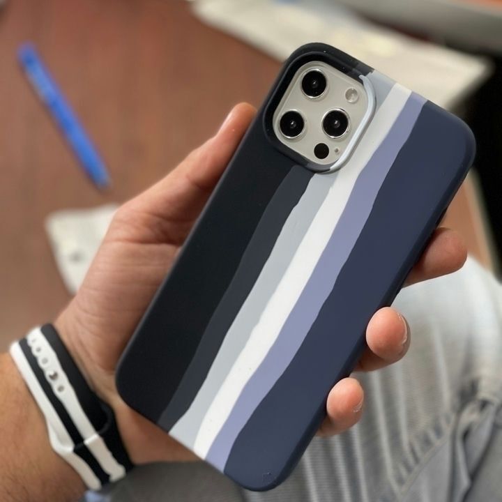  کاور سیلیکونی رنگین کمانی برای گوشی موبایل اپل iPhone 13 با طراحی منحصر به فرد و رنگ‌های متنوع در دست یک شخص 