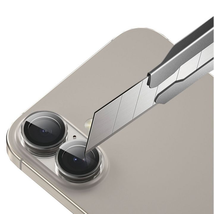 محافظ لنز DUO گرین لاین برای دوربین گوشی موبایل اپل مدل iPhone 16 / 16 Plus در حال مقاومت در برابر خط و خش با تیغ است.